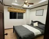 2 Bedroom Condo for Rent at Siam Oriental Twins bedroom with ceiling fan, window, and gray bedding at night