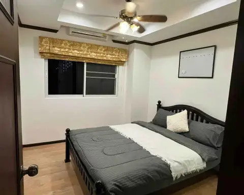 2 Bedroom Condo for Rent at Siam Oriental Twins bedroom with ceiling fan, window, and gray bedding at night
