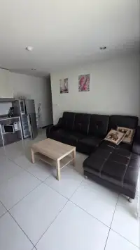 1 Bedroom Condo for Sale at Siam Oriental Tropical Garden open-plan lounge with kitchenette and sectional sofa