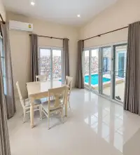 3 Bedroom House for Sale at Silk Road Place dining area with white table, chairs and pool view