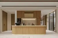 4 Bedroom House for Sale at Solava Pattaya modern kitchen with large curved wood island, stone backsplash, and built-in appliances