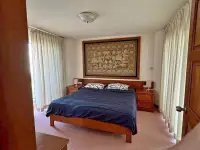 1 Bedroom Condo for Sale at Sky Beach bedroom with king bed, wooden headboard and tapestry wall art