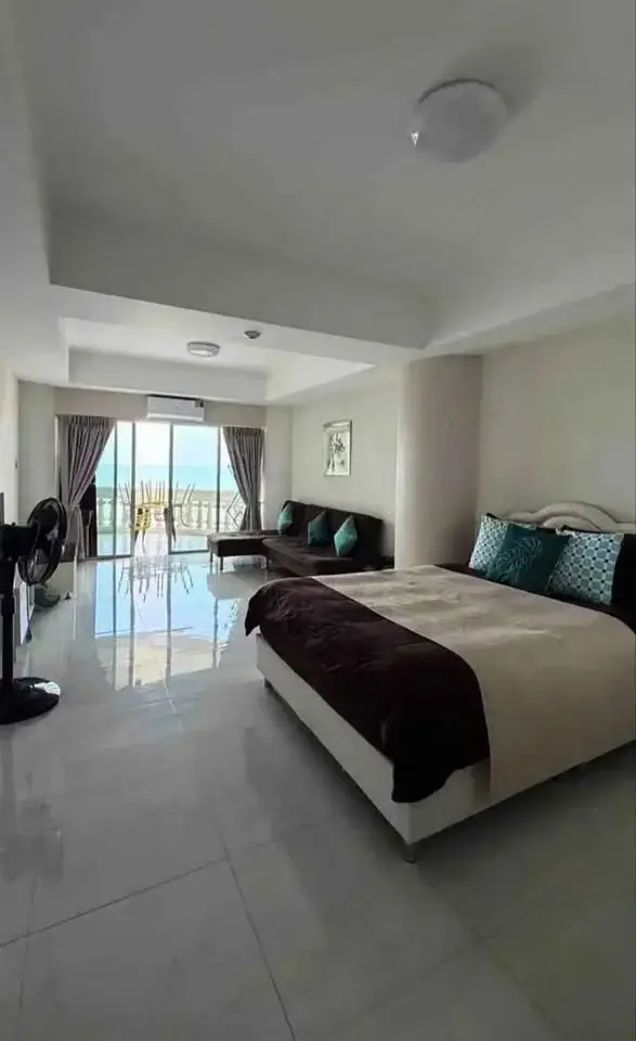 Studio Condo for Sale at Sky Beach bedroom with king bed, sofa, and sea-view balcony