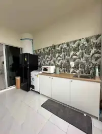 Studio Condo for Sale at Sky Beach compact kitchen with fridge, microwave, and tropical leaf backsplash