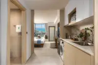 Studio Condo for Sale at SKYPARK Lucean Jomtien Pattaya window seating nook with coffee table and Jomtien beach night view