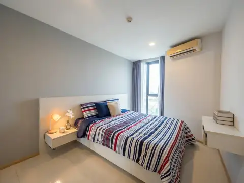 1 Bedroom Condo for Sale at Acqua Condo bedroom with striped bedding and window with city view