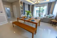 3 Bedroom House for Sale at SP Village 1 dining area with 6-seat wooden table, wishbone chairs and fitted kitchen with dark countertops