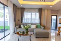 3 Bedroom House for Sale at SP Village 1 living room with grey L-shaped sectional sofa, oval wooden coffee table and floral vase