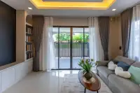 3 Bedroom House for Sale at SP Village 1 open-plan dining and living area with wooden table, bench seating and sheer curtains