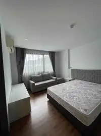 2 Bedroom Condo for Rent at Stasia Dormy Residence bedroom with sofa seating area and curtained window