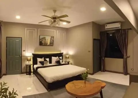 5 Bedroom House for Rent at Suksabai Villa bedroom with king bed, ceiling fan, and framed wall art