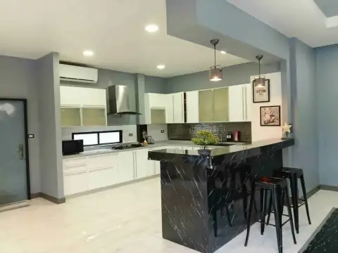 5 Bedroom House for Rent at Suksabai Villa open-plan kitchen with white cabinets and marble breakfast bar