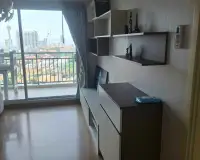 1 Bedroom Condo for Sale at Supalai Mare Pattaya living area with wall shelving, storage cabinet and balcony access