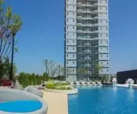 1 Bedroom Condo for Sale at Supalai Mare Pattaya building exterior with outdoor swimming pool and loungers