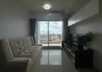 1 Bedroom Condo for Sale at Supalai Mare Pattaya living room with sofa, balcony access and city view