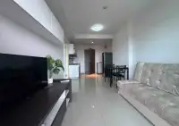 1 Bedroom Condo for Sale at Supalai Mare Pattaya open-plan living area with TV unit, dining table and kitchenette