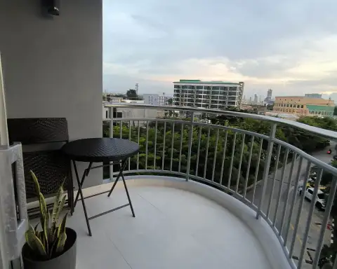 2 Bedroom Condo for Rent at Supalai Mare Pattaya curved balcony with bistro table and city skyline view