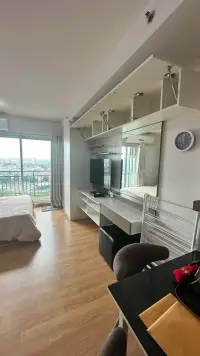 Studio Condo for Rent at Supalai Mare Pattaya living area with built-in cabinets, TV unit and balcony view