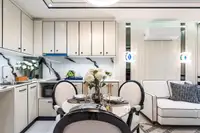 2 Bedroom Condo for Sale at Embassy Life, dining table with floral centerpiece, kitchen, and white sofa in living area.