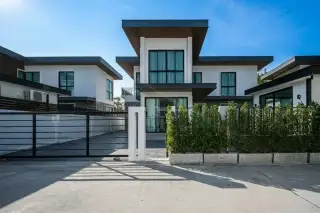 Aqua Pool Villa by Vinyx Pattaya aerial view of modern villas with grey roofs and brown accents along a street.