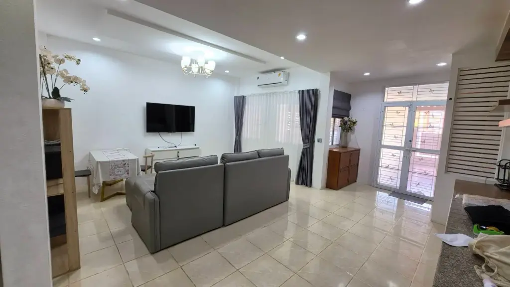 3 Bedroom House for Rent at T.W. Palm Resort living room with gray sofa, TV and dining area