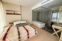 1 Bedroom Condo for Rent at Cetus Beachfront bedroom with double bed, glass-enclosed bathtub, and rain shower