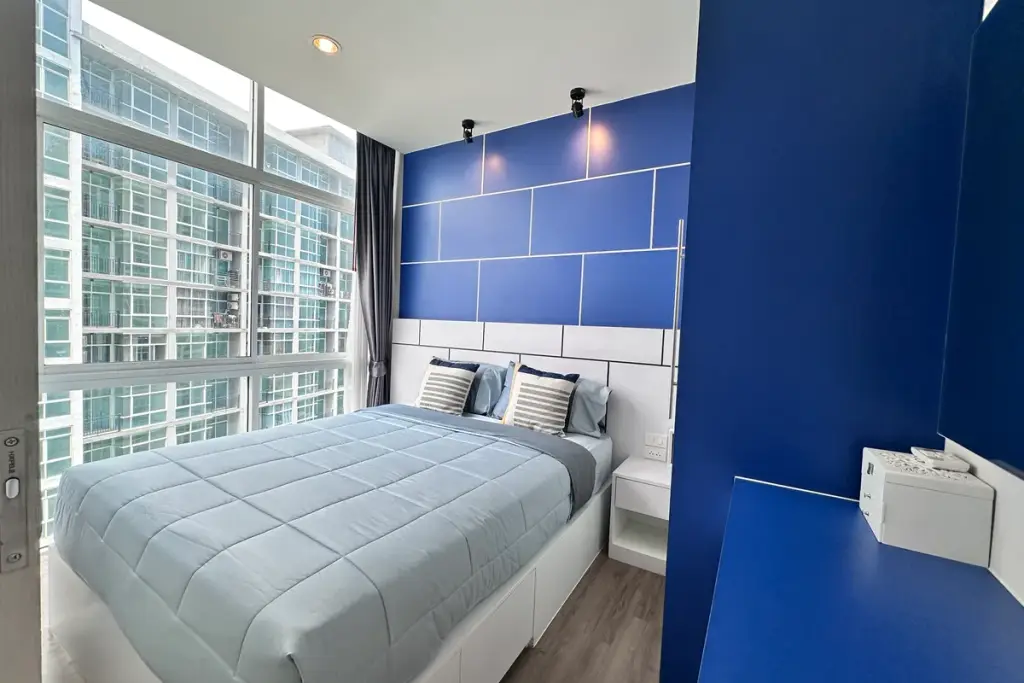 1 Bedroom Condo for Sale at The Twin Tower Jomtien Beach Pattaya bedroom with blue accent wall and floor-to-ceiling windows