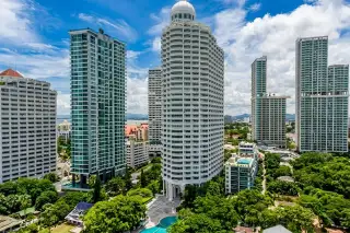 Park Beach Condominium large outdoor swimming pool with a building and lush trees in the background
