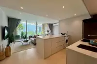 2 Bedroom Condo for Sale at Celine Wongamat modern kitchen with integrated washing machine, looking towards living area.