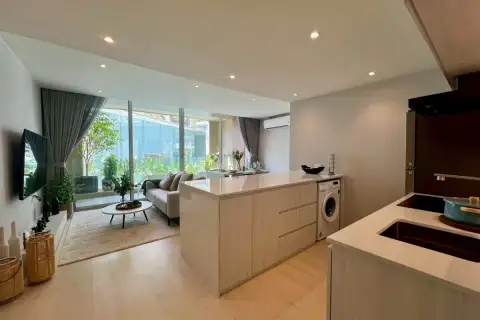 2 Bedroom Condo for Sale at Celine Wongamat modern kitchen with integrated washing machine, looking towards living area.