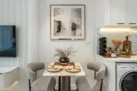 Studio Condo for Sale at Seaspire Jomtien: Small dining area with a square table, two chairs, and abstract art.
