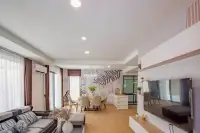 4 Bedroom House for Rent in Takhian Tia open-plan living and dining area with leaf-pattern accent wall