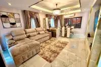4 Bedroom House for Rent in Takhian Tia spacious living room with beige sectional sofa and marble floors