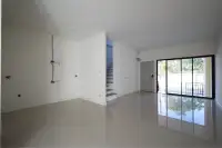 4 Bedroom Townhouse for Sale in Takhian Tia open living area with glossy tile floor, staircase, and sliding glass door to patio