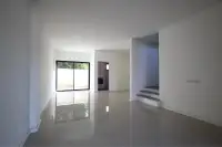4 Bedroom Townhouse for Sale in Takhian Tia spacious living room with tiled floor, staircase, and sliding door to outside wall