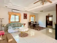 3 Bedroom House for Sale & Rent in East Pattaya second living area with green sofa, dining table and tiled flooring