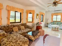 3 Bedroom House for Sale & Rent in East Pattaya living room with floral sectional sofa, curtained windows and ceiling fan