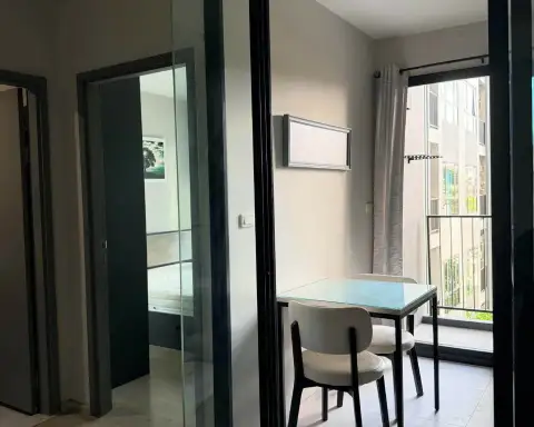 1 Bedroom Condo for Rent at The Base Central Pattaya glass dining table and balcony view of bedroom through sliding doors