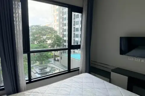 1 Bedroom Condo for Rent at The Base Central Pattaya bedroom window view overlooking swimming pool and city buildings