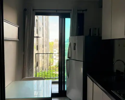 1 Bedroom Condo for Rent at The Base Central Pattaya kitchen with refrigerator and balcony view of surrounding buildings