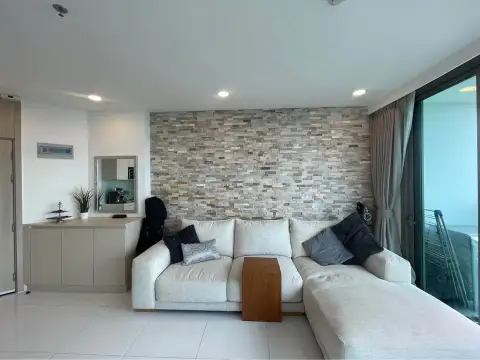 1 Bedroom Condo for Sale at The Cloud lounge area with stone accent wall and white sectional sofa