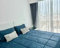 1 Bedroom Condo for Rent at The Empire Tower Pattaya bedroom with blue bedding and sheer curtains