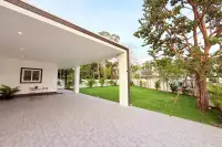 3 Bedroom House for Sale at The Flow Pong - Mabprachan spacious covered carport with tiled floor overlooking manicured lawn and mature trees
