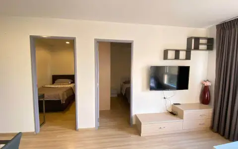 2 Bedroom Condo for Rent at The Grass hallway view into two bedrooms with wall-mounted TV and shelving