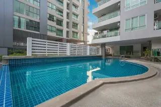 The Lofts Pratumnak outdoor swimming pool with blue tiles, surrounded by modern condo buildings.