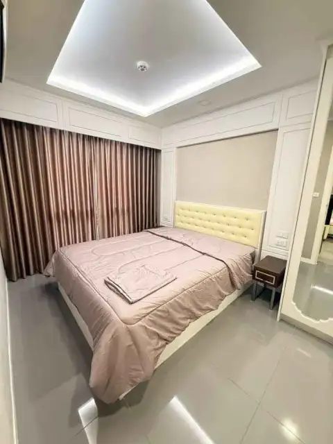 2 Bedroom Condo for Rent at The Orient Resort & Spa master bedroom with tufted headboard and curtains