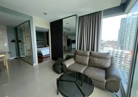 2 Bedroom Condo for Rent at Palm Wongamat open-plan living room with leather sofa and city view windows
