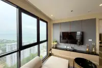 2 Bedroom Condo for Sale at The Panora Pattaya living room with wall-mounted TV and floor-to-ceiling sea view windows