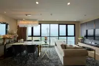 2 Bedroom Condo for Sale at The Panora Pattaya living room with plush sofa, dining table and panoramic ocean view