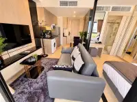 1 Bedroom Condo for Rent at The Panora Pattaya grey leather sofa with view toward bedroom and en-suite bathroom